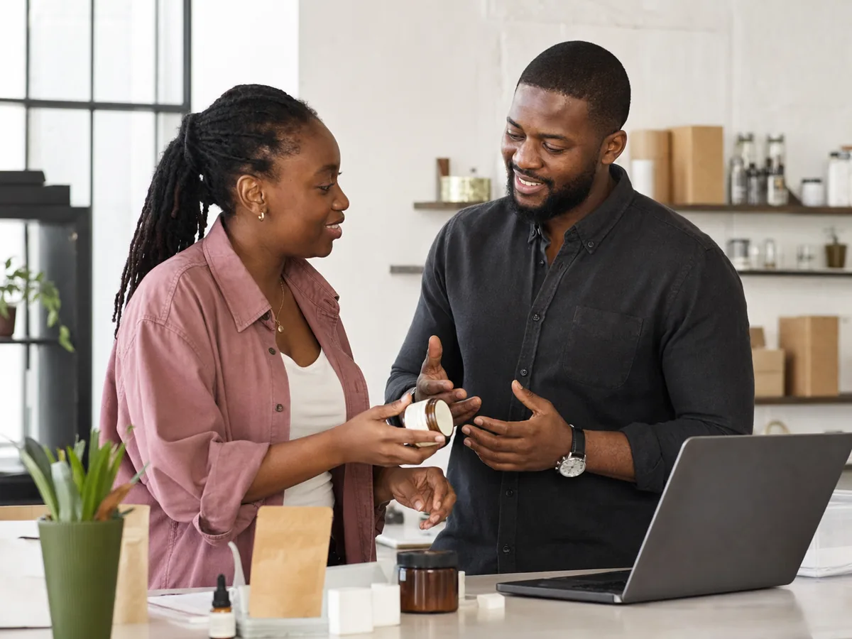 Two Ghanaian business owners discussing a product in an Accra studio